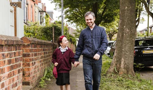 Dad and daughter walking to school