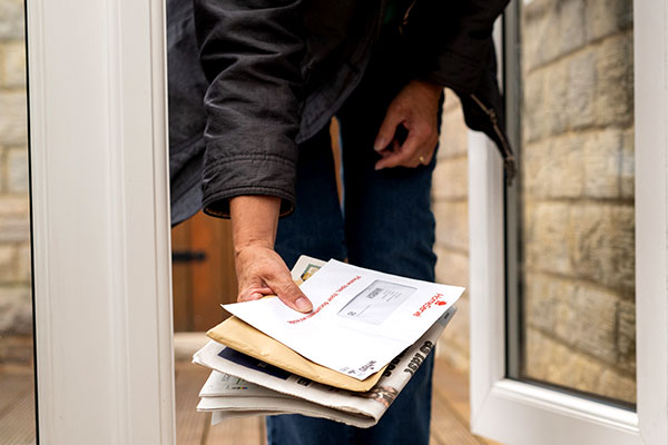 woman at door with bills