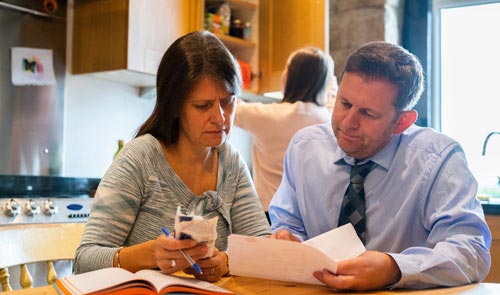 Couple sat at kitchen table with paperwork
