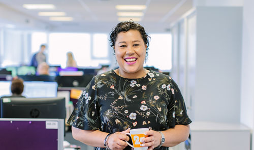 smiling woman holding a cup of coffee