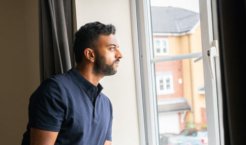 man looking out window