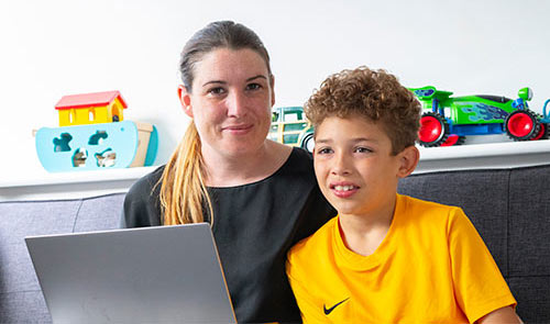 mum sat with her son using a laptop