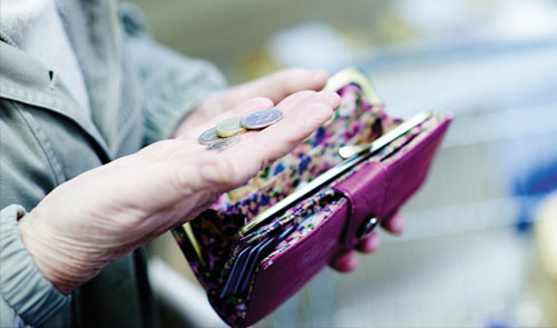 woman holding coins from her purse