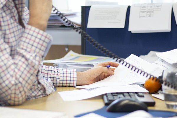 Advisor on the phone reading paper forms.