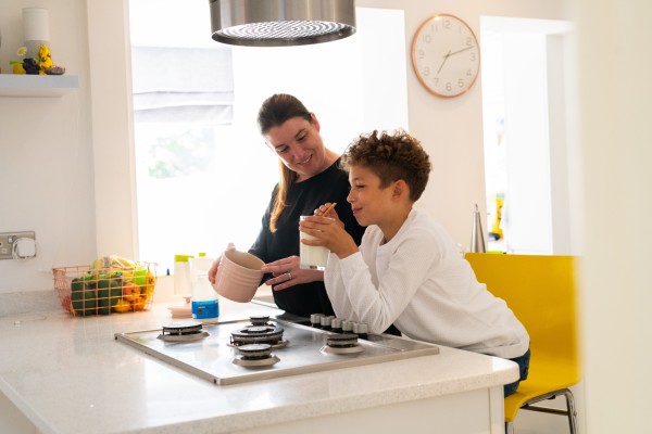 A woman cooking with her son