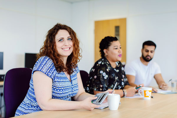 two female colleagues smiling in a meeting