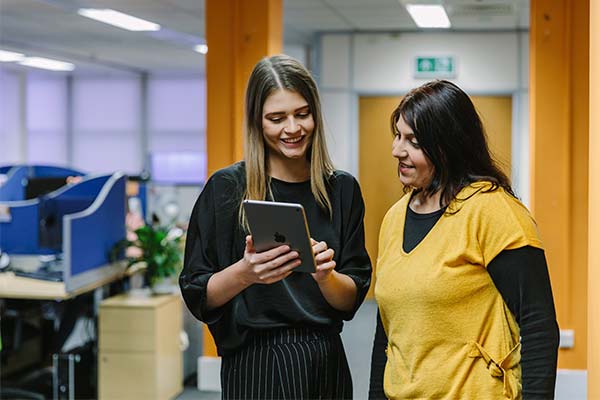 two female colleagues on an iPad