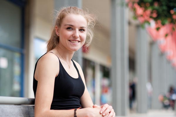 woman outside shopping centre smiling