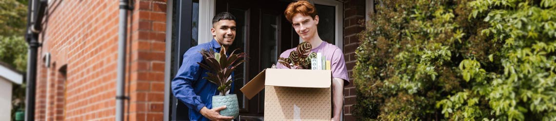 Photo of young men moving into a new home