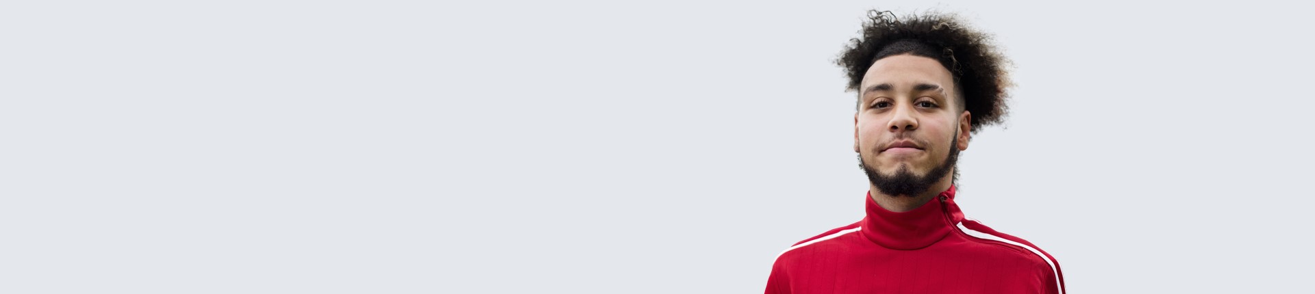 man on grey background looking towards the camera