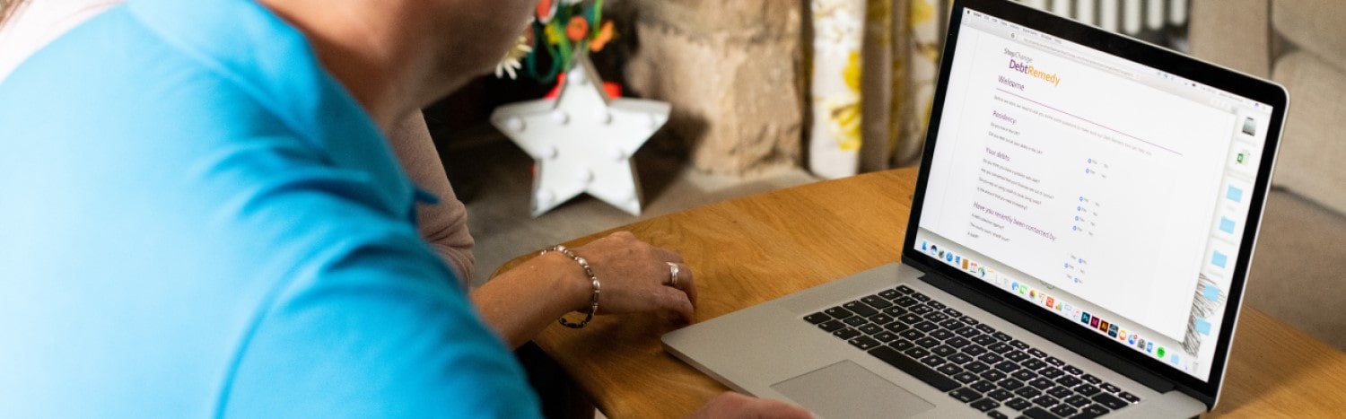 Couple looking at StepChange website on their laptop