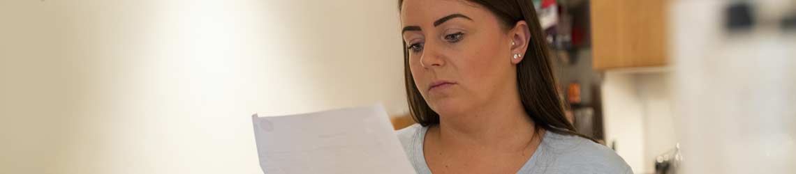Woman looking worried as she reads a letter
