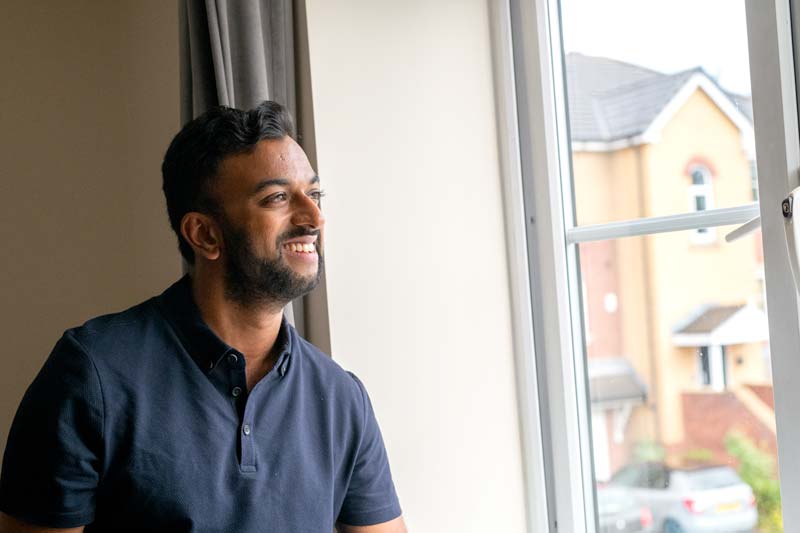 man at a window smiling