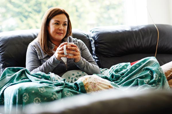 Woman on her sofa with a cup of tea