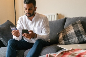 man with phone and bankcard in hand