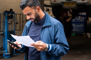 man at a garage with his phone