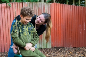 mum pushing son on swing