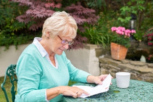 woman reading bills in garden