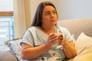 woman on the sofa in pjs with a cup of tea