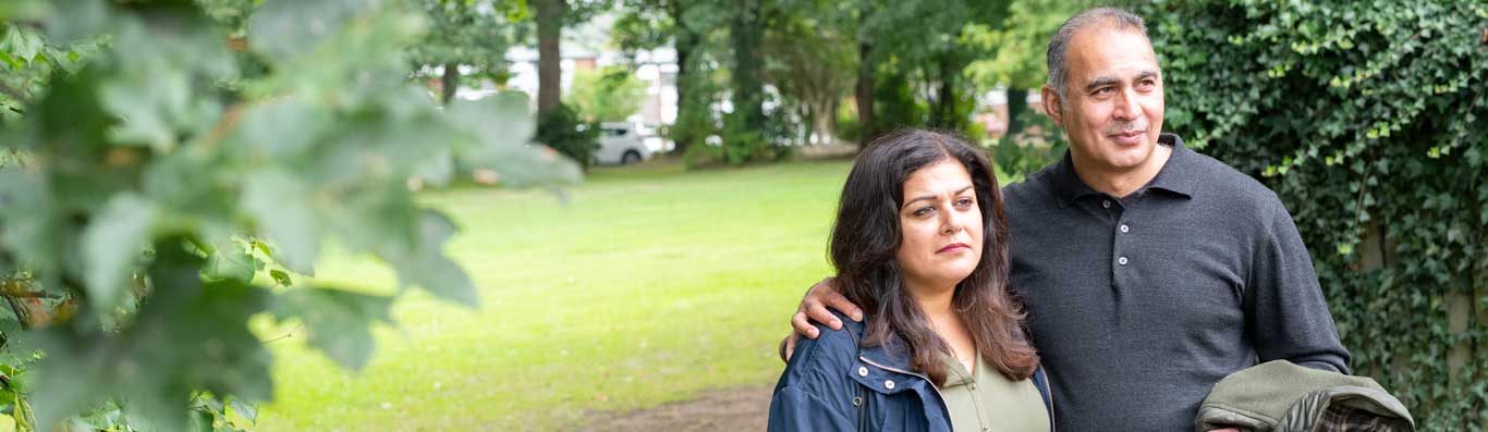 A man and woman in their fifties standing in a park